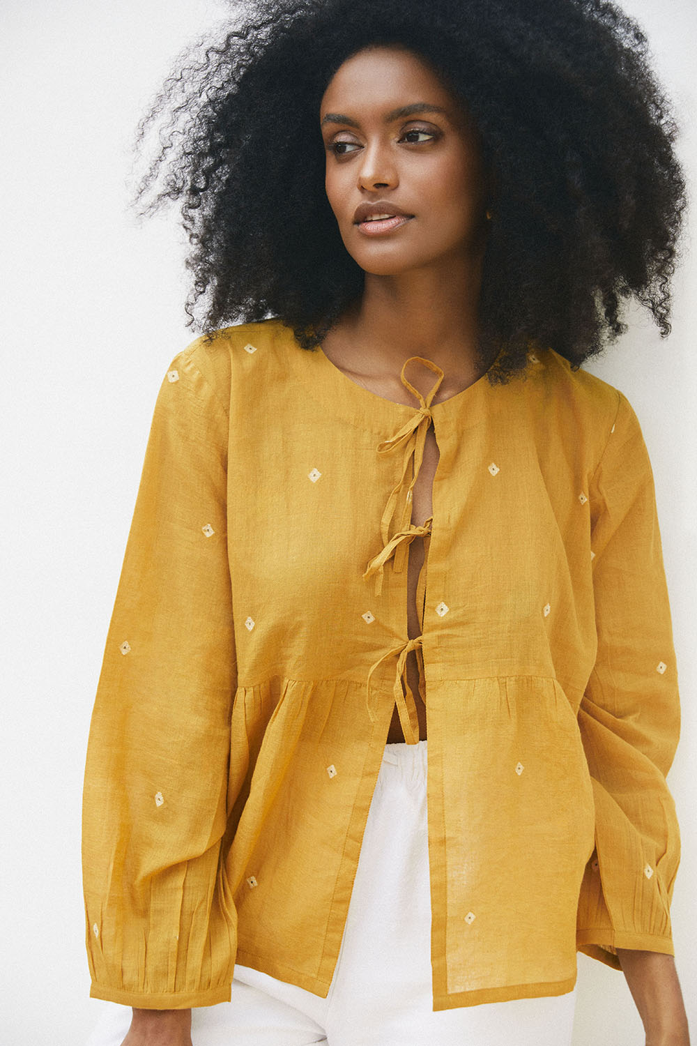 Model wearing the Golden Hues Front Tie Top in marigold yellow, featuring tie-up front and subtle embroidered motifs.